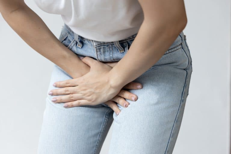 Mulher com desconforto na região abdominal e pélvica, ilustrando sintomas comuns de Infecção urinária.