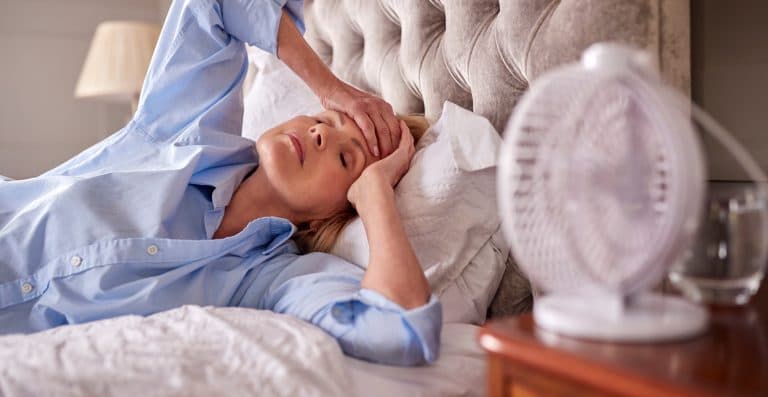 Mulher com calorões da menopausa, enfrentando desconforto e dificuldade para dormir.