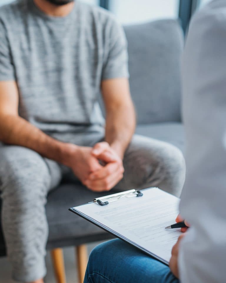 Homem em consulta com profissional de saúde, ilustrando orientações sobre PEP e PREP.