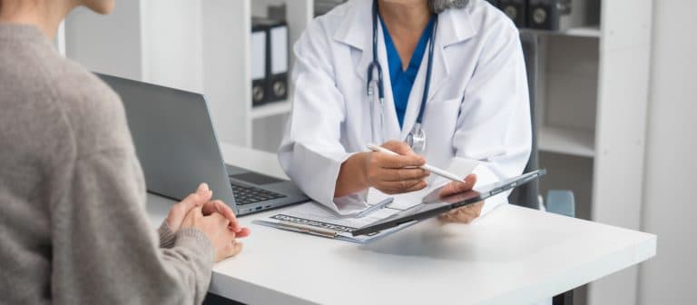 Médica orienta paciente durante consulta, explicando cuidados do pré-operatório e do pós-operatório, destacando medidas importantes para uma recuperação segura e mais rápida.
